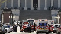 Mobil ambulans dan kendaraan darurat disiagakan di depan Gedung Capitol, Washington DC, Amerika Serikat, pascapenembakan di lokasi tersebut, Senin (28/3). Sempat terjadi tembak-menembak dengan petugas sebelum pelaku dilumpuhkan. (REUTERS/Joshua Roberts)
