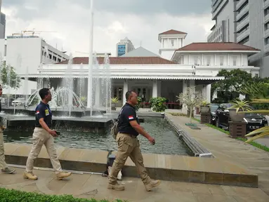 Sejumlah anggota polisi berjalan di depan Balai Kota DKI Jakarta, setelah menerima ancaman teror bom dari orang tak dikenal, Rabu (20/7). Saat ini, pengamanan kantor Gubernur Basuki Tjahaja Purnama (Ahok) diperketat. (Liputan6.com/Gempur M Surya)