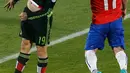 Penyerang Meksiko, Vicente Vuoso berebut bola udara dengan bek Chile Gary Medel saat pertandingan Copa America 2015 di National Stadium, Santiago, Chile, (16/6/2015). Chile bermain imbang 3-3 dengan Meksiko. (REUTERS/Carlos Garcia Rawlins)