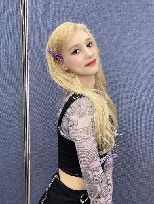 Tetap dengan rambut blondenya Bahiyyih, ia menambah aksesori seperti jepitan warna ungu berkilau. Ia mengenakan longslevee motif koran dengan luaran hitam.  (@kep1er.world)