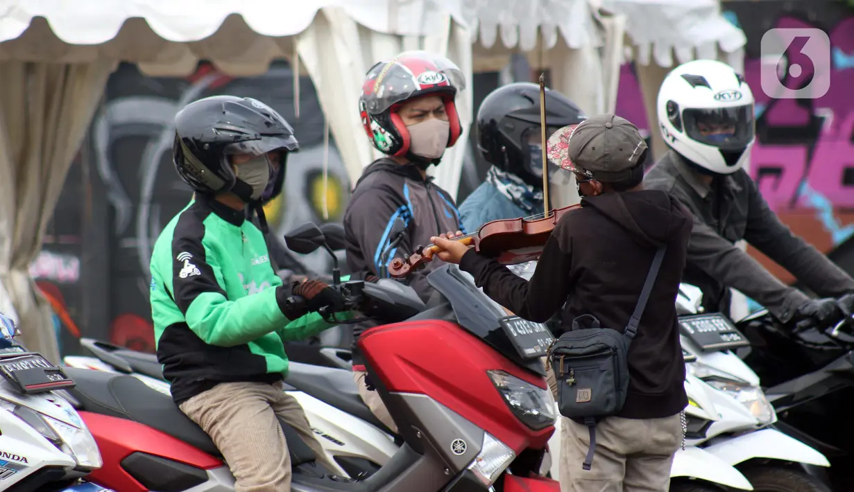 Pengamen menampilkan aksinya di Jalan Margonda Raya, Depok, Kamis (16/4/2020). Pandemi COVID-19 memberikan dampak yang sangat besar bagi sosial dan ekonomi Indonesia. Bahkan yang paling dikhawatirkan bertambahnya angka kemiskinan dan pengangguran. (Liputan6.com/Helmi Fithriansyah)