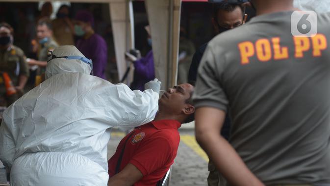Petugas medis mengambil sampel lendir saat tes usap (swab test) pegawai kecamatan Sawah Besar, Jakarta, Selasa (18/8/2020). Tes swab yang dilakukan terhadap seluruh pegawai kecamatan Sawah Besar itu sebagai upaya memutus mata rantai penyebaran Virus Corona Covid-19. (merdeka.com/Imam Buhori)