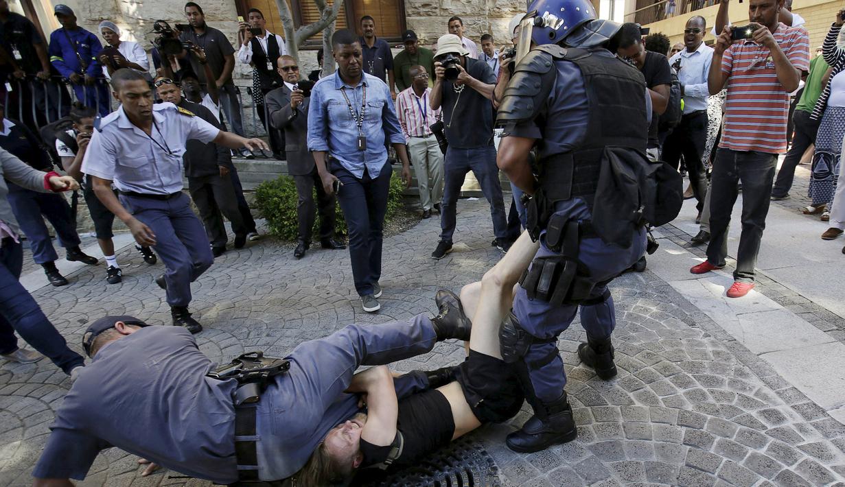 Polisi bentrok dengan pelajar di luar Parlemen Afrika Selatan di Cape Town, Rabu (21/10). Polisi anti huru hara menembakkan gas airmata kepada ratusan pelajar yang berdemonstrasi menentang rencana kenaikan uang sekolah. (REUTERS/Mark Wessels)
