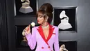 Andra Day berpose sambil memegang bunga saat menghadiri Grammy Awards ke-60 di Madison Square Garden, New York (28/1). (Photo by Evan Agostini/Invision/AP)