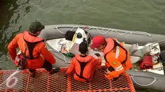 Petugas  gabungan bersiap menaiki perahu karet saat mencari korban latihan terjun payung yang jatuh di seputar perairan pantai Semarang, Selasa (7/2). Korban adalah prajurit Kopassus yang diduga jatuh ke laut akibat cuaca buruk. (Liputan6.com/Gholib)