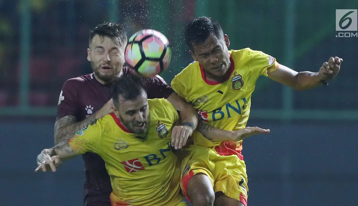Gelandang PSM Makassar, Marc Anthony Klok (kiri) berebut bola atas dengan dua pemain Bhayangkara FC pada lanjutan Liga 1 Indonesia di Stadion Patriot Candrabhaga, Bekasi, Kamis (19/10). PSM Makassar unggul 2-0. (Liputan6.com/Helmi Fithriansyah)