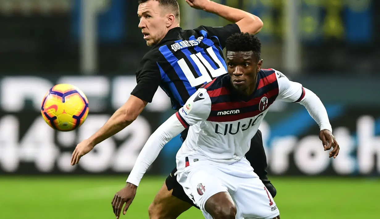 Duel antara Ibrhima Mbaye dan Ivan Perisic pada lanjutan Serie A yang berlangsung di stadion Giuseppe Meazza, Milan, Minggu (3/2). Inter Milan kalah 0-1 kontra Bologna. (AFP/Miguel Medina)