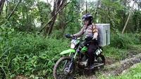 Demi membawa kotak suara, polwan rela mengendarai motor trail. | via: Krishna Murti/Facebook