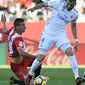 Pemain Girona, Pere Pons (kiri) berusaha menahan laju pemain Real Madrid, Karim Benzema pada lanjutan La Liga Santander di Municipal de Montilivi stadium, Girona , (29/10/2017). Madrid kalah 1-2. (AFP/Josep Lago)