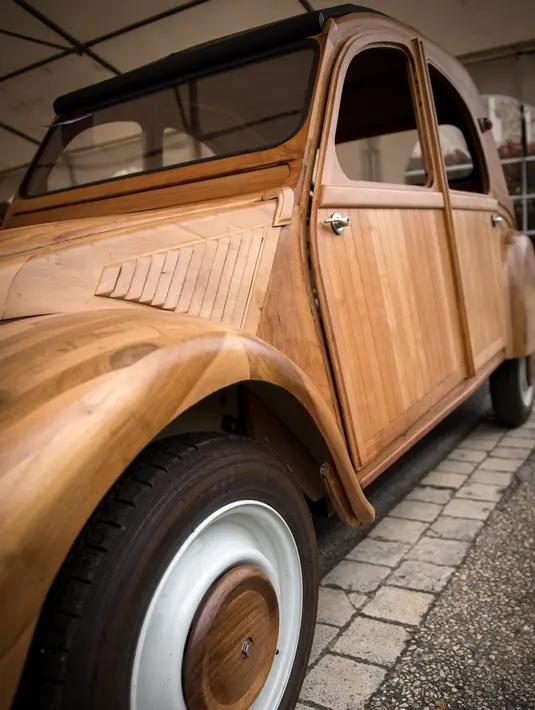 Replika mobil legendaris Citroen 2CV buatan seorang pensiunan tukang lemari, Michael Robillard, di bengkel kerjanya di Loches, Prancis, 21 Maret 2017. Sekujur bodi mobil ini diketahui menggunakan bahan dasar kayu jenis Touraine. (GUILLAUME SOUVANT/AFP)