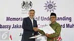 Dubes Inggris untuk Indonesia Moazzam Malik (kiri) bersama Ketua Umum PP Muhammadiyah Haedar Nasir melakukan penandatanganan nota kesepahaman di Jakarta, Senin (16/5). (Liputan6.com/Immanuel Antonius)