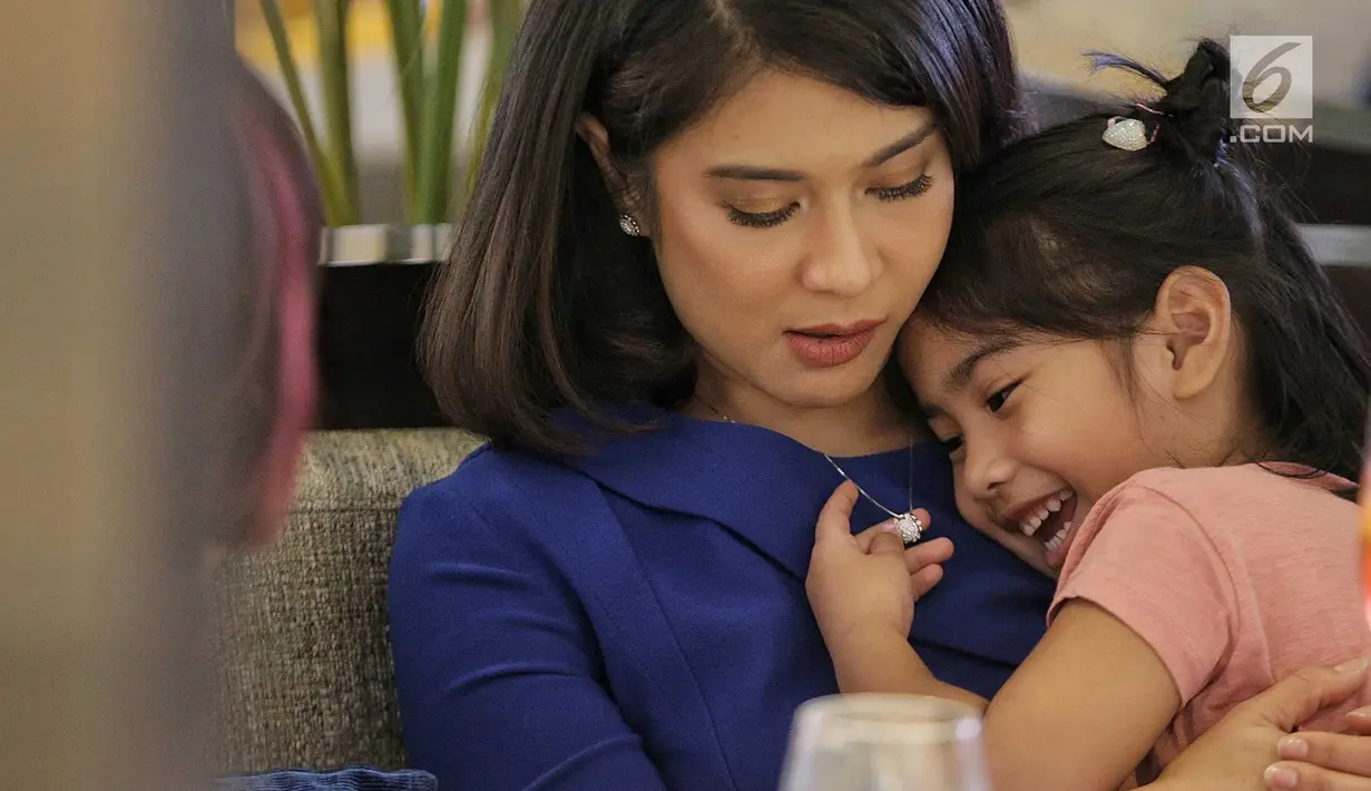 Artis Dian Sastrowardoyo sebagai Brand ambassador Mondial Jeweler memeluk sang anak saat menjadi pembicara di Plaza Indonesia, Jakarta, Jumat (27/7). Soal jenis perhiasan, Dian mengaku lebih suka kalung daripada yang lainnya. (Liputan6.com/Faizal Fanani)