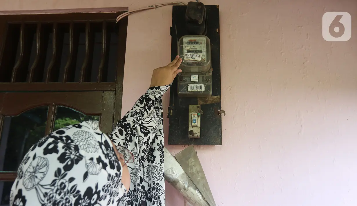 Warga memeriksa meteran listrik di kawasan Matraman, Jakarta, Kamis (2/4/2020). Di tengah pandemi COVID-19, pemerintah menggratiskan biaya tarif listrik bagi konsumen 450 Volt Ampere (VA) dan pemberian keringanan tagihan 50 persen kepada konsumen bersubsidi 900 VA. (Liputan6.com/Herman Zakharia)