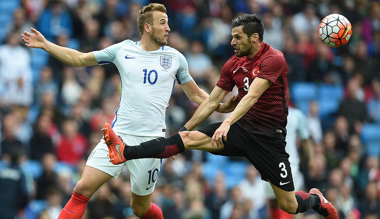 Striker Inggris, Harry Kane, berusaha melewati bek Turki, Hakan Balta, pada laga persahabatan. Bomber Tottenham ini berhasil membobol gawang Turki pada menit ketiga. (AFP/Paul Ellis)