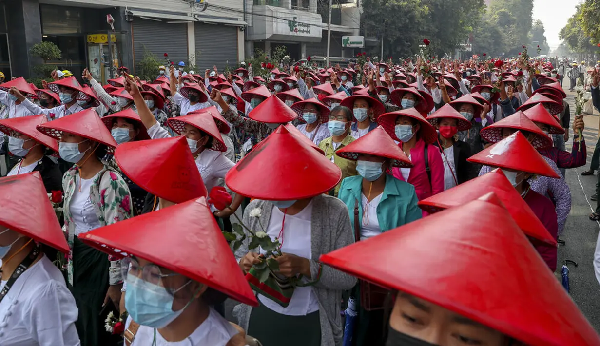 Guru sekolah antikudeta mengenakan seragam dan topi tradisional Myanmar menunjukkan penghormatan tiga jari saat berdemonstrasi di Mandalay, Myanmar, Rabu (3/3/2021). Demonstran di Myanmar turun ke jalan lagi pada hari Rabu untuk memprotes perebutan kekuasaan bulan lalu oleh militer. (AP Photo)
