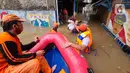 Petugas PPSU memberi bantuan nasi bungkus kepada warga yang bertahan saat banjir di kawasan pemukiman Jalan Bango, Pondok Labu, Jakarta Selatan, Sabtu (20/2/2021). Banjir akibat luapan Kali Krukut yang melanda sejak semalam menyebabkan pemukiman tergenang hingga dua meter. (merdeka.com/Arie Basuki)