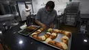 Chef Francisco Vasquez menghias kue tradisional Rosca de Reyes di toko rotinya sehari sebelum Epiphany atau Hari Tiga Raja, Mexico City, Meksiko, 5 Januari 2022. (AP Photo/Fernando Llano)