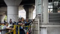 Warga berkerumun di Halte TransJakarta Kampung Melayu, yang tidak beroperasi karena terdampak ledakan bom, Kamis (25/5). Warga terus berdatangan untuk melihat langsung lokasi ledakan bom yang menewaskan tiga polisi tersebut. (Liputan6.com/Faizal Fanani)