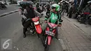 Petugas menghalau salah satu pengemudi ojek online di kawasan Senayan, Jakarta, Selasa (22/3). Pascabentrok ojek online melakukan sweeping dan perusakan terhadap taksi serta bajaj yang melintas di kawasan tersebut. (Liputan6.com/Immanuel Antonius)