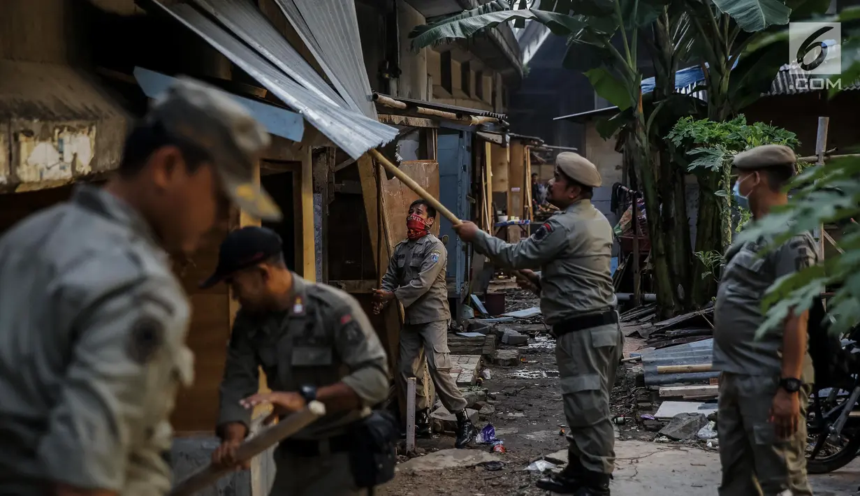 Petugas satpol PP membongkar bedengnya di bawah kolong Tol Teluk Intan, Jakarta, Rabu (14/6). Gubernur DKI Jakarta Djarot Saiful Hidayat menegaskan, kawasan tersebut dilarang digunakan sebagai tempat pemukiman. (Liputan6.com/Faizal Fanani)