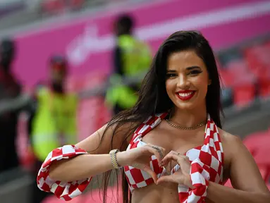 Seorang fans wanita Kroasia berpose menjelang pertandingan Grup F Piala Dunia 2022 Qatar antara Kroasia dan Belgia di Stadion Ahmad Bin Ali di Al-Rayyan, barat Doha pada 1 Desember 2022. (AFP/Ozan Kose)