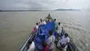 Saat persalinannya berlangsung, tim di atas perahu dengan cepat mulai bekerja, mengangkat terpal untuk melindungi dari hujan saat mereka membantu persalinan. (AP Photo/Anupam Nath)