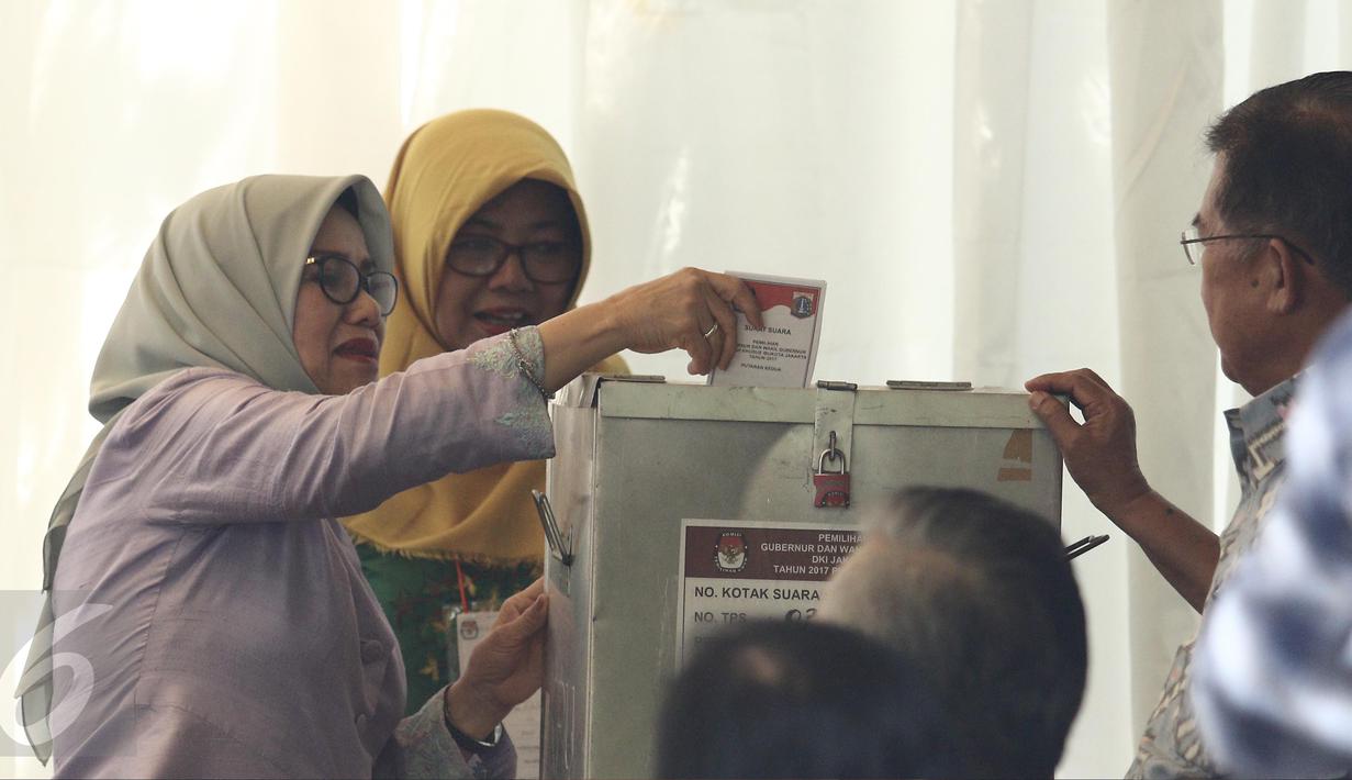 Istri Wapres Jusuf Kalla (JK), Mufidah Kalla, memasukkan surat suara usai mencoblos di TPS 03 Kelurahan Pulo, Jakarta Selatan, Rabu (19/4). Di TPS bernuansa Betawi itu, JK dan istri memberikan suaranya pada Pilkada DKI 2017. (Liputan6.com/Herman Zakharia)