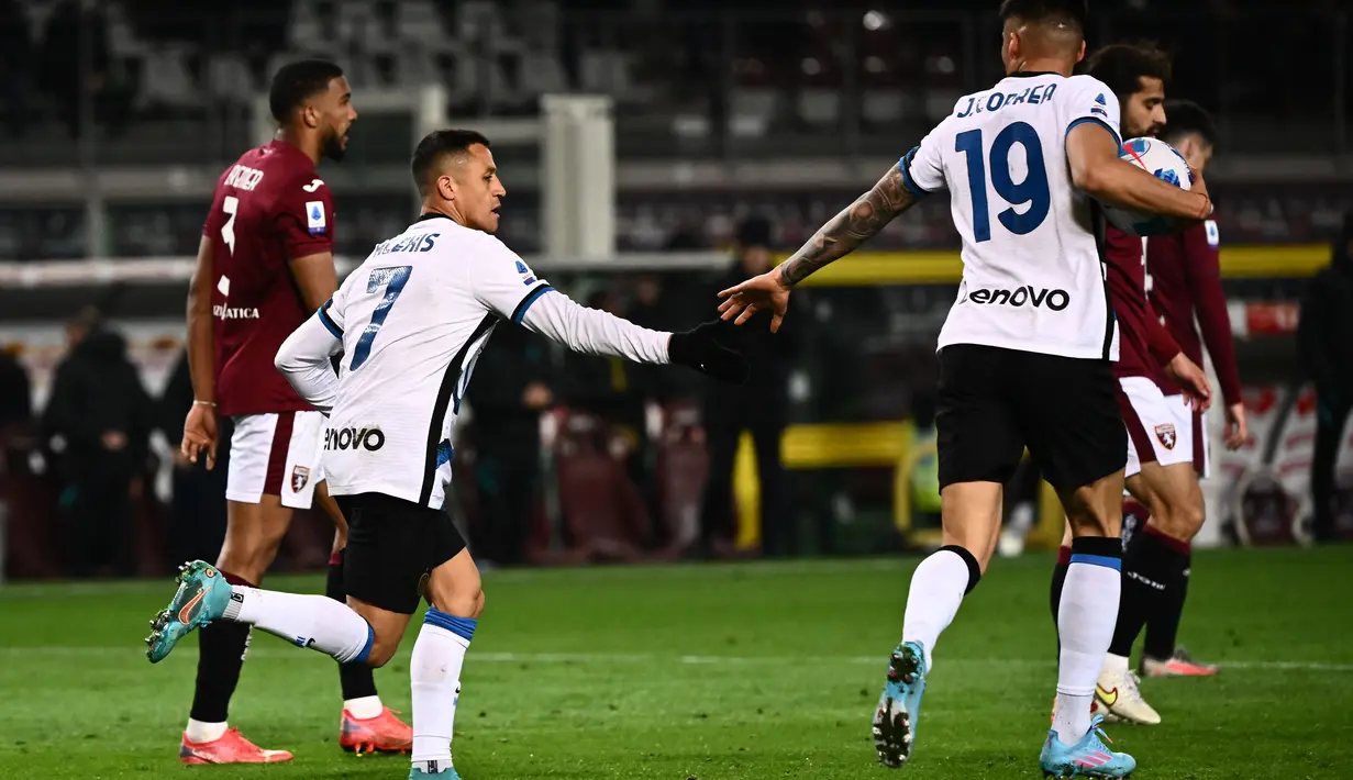 Penyerang Alexis Sanchez (kiri) berselebrasi usai mencetak gol ke gawang Torino menit 93+3 pada pertandingan lanjutan Liga Serie A Italia di stadion Olimpiade di Turin, Senin (14/3/2022). Torino bermain imbang atas Inter Milan 1-1. (AFP/Marco Bertorello)