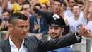 Bintang baru Juventus, Cristiano Ronaldo, menyapa suporter saat tiba untuk menjalani tes kesehatan di area Stadion Allianz, Turin, Senin (17/7/2018). CR 7 hijrah dari Real Madrid ke Juventus. (AFP/Miguel Medina)