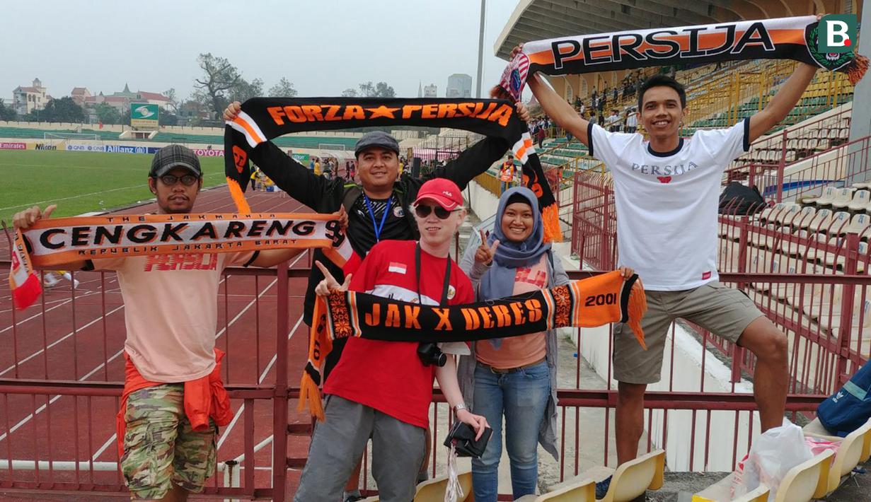 Suporter Persija Jakarta, The Jakmania, berpose dengan syal usai menyaksikan laga Piala AFC melawan Song Lam Nghe An di Stadion Vinh, Vietnam, Selasa (6/3/2018). Kedua klub bermain imbang 0-0. (Bola.com/Reza Khomaini)