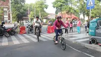 Wali Kota Surabaya, Tri Rismaharini, bersepeda dari rumah menuju kantor. Ia ditemani beberapa pejabat di lingkungan Pemkot Surabaya, Jatim. (Liputan6.com/Dian Kurniawan)