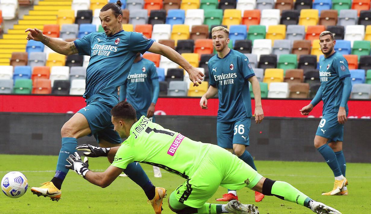 Striker AC Milan, Zlatan Ibrahimovic, berusaha melewati kiper Udinese, Juan Musso, pada laga Liga Italia di Stadion Friuli, Minggu (1/11/2020). AC Milan menang dengan skor 2-1. (Andrea Bressanutti/LaPresse via AP)