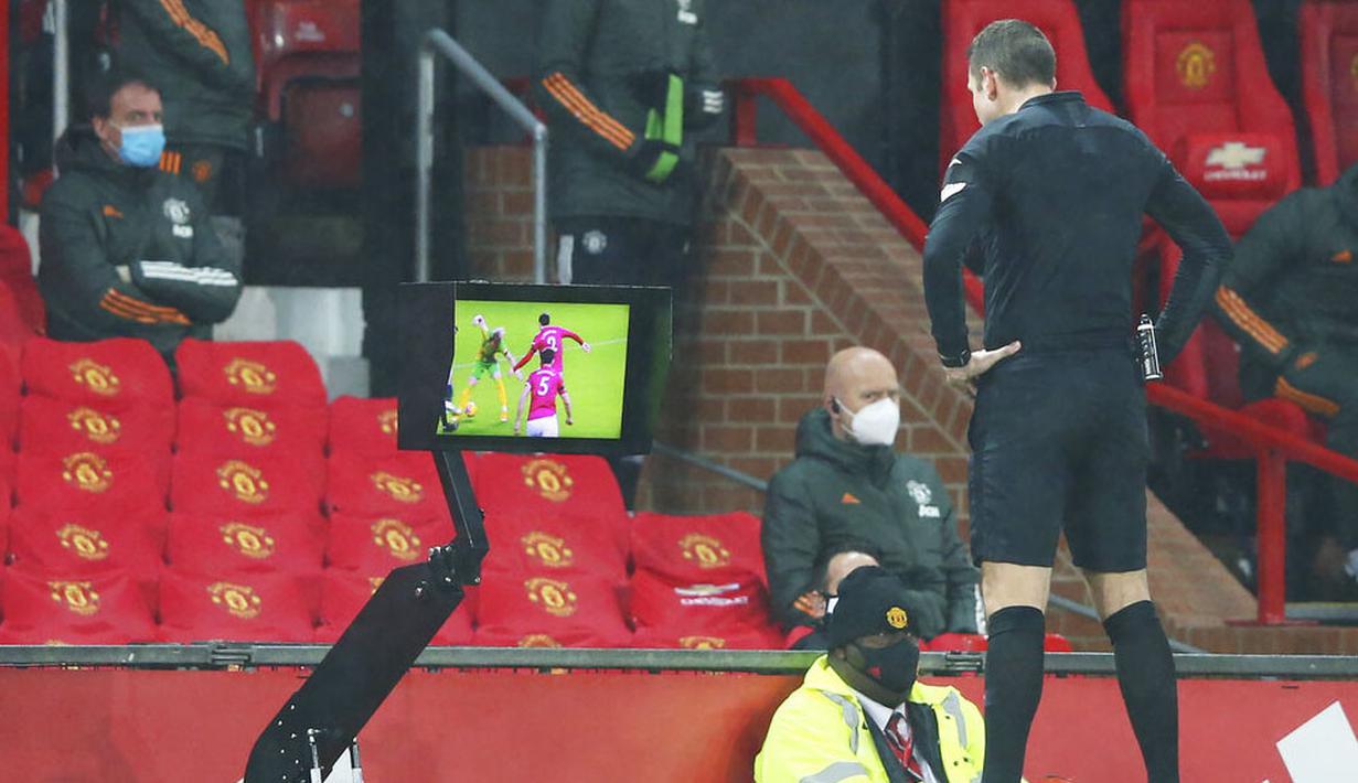 Wasit David Coote melihat layar VAR saat pertandingan Manchester United melawan West Bromwich Albion pada laga Liga Inggris di Stadion Old Trafford, Minggu (22/11/2020). MU menang dengan skor 1-0. (Alex Livesey/Pool via AP)