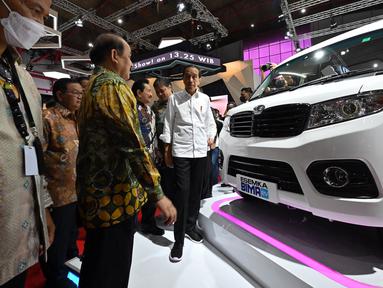 Presiden Joko Widodo atau Jokowi (tengah) melihat mobil listrik Esemka Bima EV saat mengunjungi pameran Indonesia International Motor Show (IIMS) di JIExpo, Kemayoran, Jakarta, Kamis (16/2/2023). Jokowi resmi membuka IIMS 2023. (ADEK BERRY/AFP)