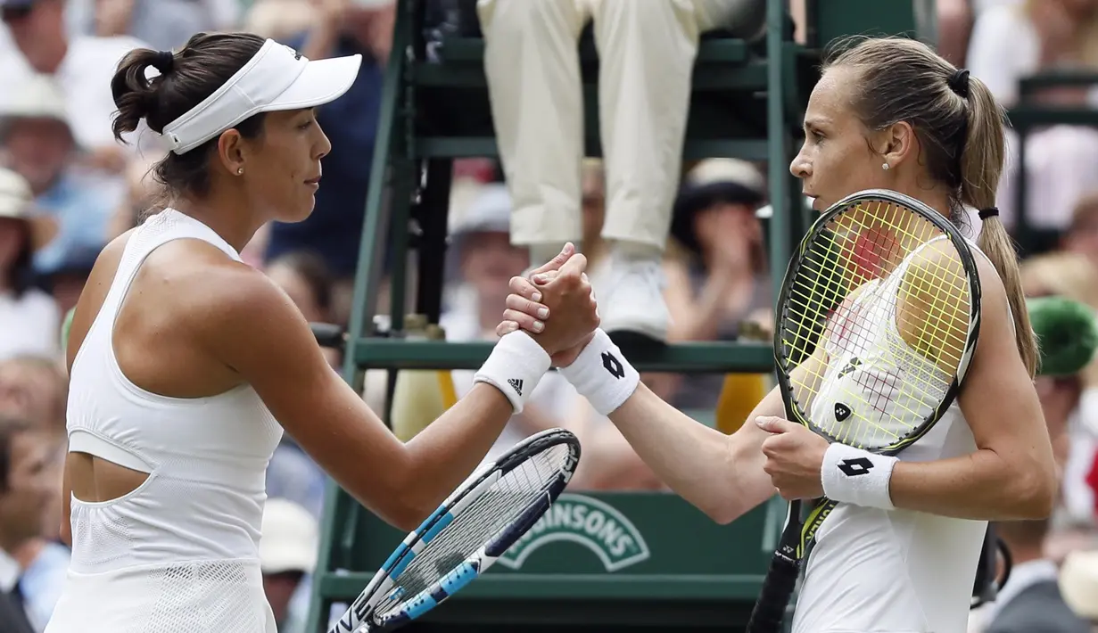Garbine Muguruza (kiri) bersalaman dengan Magdalena Rybarikova usai laga semifinal tunggal putri Wimbledon 2017 di London; (13/7/2017). Muguruza menang 6-1, 6-1. (AP/Kirsty Wigglesworth)