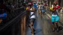 Orang-orang saling tembak menggunakan pistol air saat perang air tahunan di jalan-jalan lingkungan Vallecas, Madrid, Spanyol, 17 Juli 2022. Semua orang menerima dan memberikan tembakan. (AP Photo/Manu Fernandez)