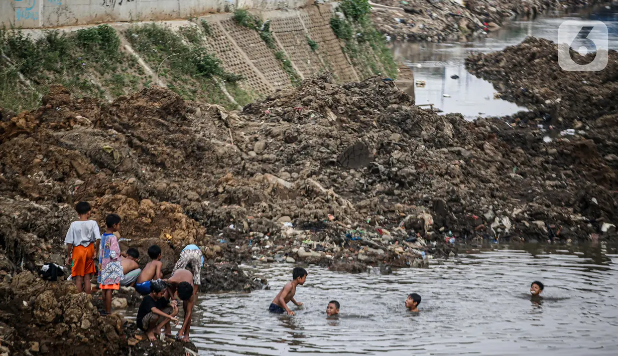 Anak-anak bermain di Sungai Ciliwung yang surut di kawasan Bukit Duri, Jakarta, Sabtu (8/8/2020). Penyusutan debit air Sungai Ciliwung tersebut karena memasuki masa kemarau 2020 yang menurut BMKG akan mencapai puncaknya pada Agustus. (Liputan6.com/Faizal Fanani)