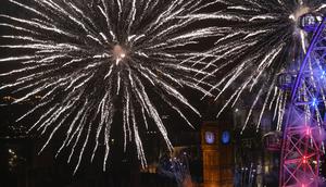 Kembang api memancar di sekitar The Elizabeth Tower, juga dikenal sebagai 'Big Ben' dan London Eye saat perayaan Tahun Baru di London, Inggris (1/1/2016). (AFP Photo / Justin Tallis)