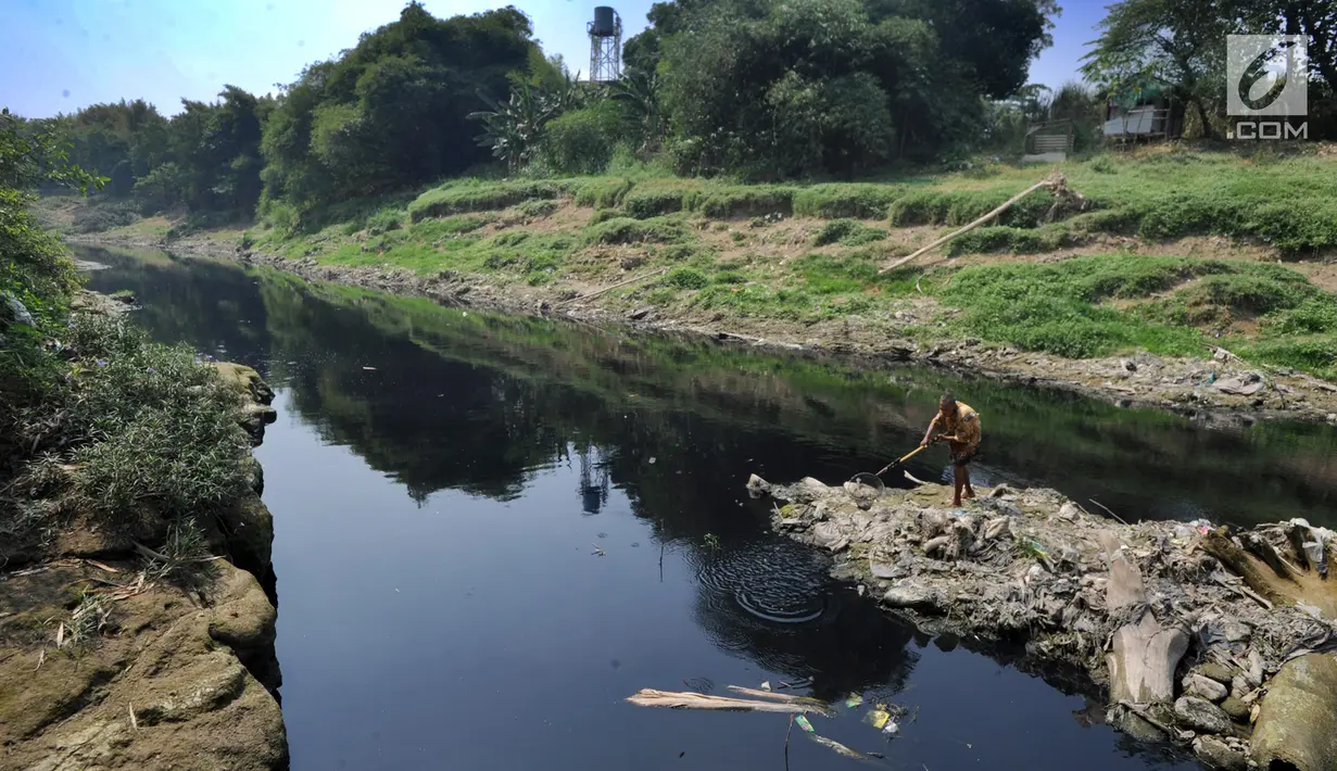 Warga mencari ikan di aliran Sungai Cileungsi yang berwarna hitam pekat di kawasan Bojong Kulur, Gunung Putri, Kabupaten Bogor, Jawa Barat, Selasa (23/7/2019). Air Sungai Cileungsi diduga  tercemar limbah pabrik sehingga menyebabkan ikan mati dan menimbulkan bau tak sedap. (merdeka.com/Arie Basuki)