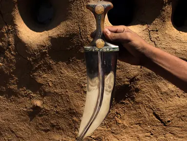 Foto 6 Oktober 2018, perajin memegang pisau tradisional, jambiya, yang terbuat dari sisa-sisa rudal di Hajjah, Yaman. Serpihan logam sisa-sisa dari rudal yang ditembakkan Koalisi Arab Saudi dikumpulkan dan diubah menjadi belati jambiya. (AP/Hammadi Issa)