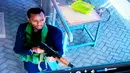 Pria bersenjata berjalan di sebuah kompleks hotel mewah di Nairobi, Kenya, Selasa (15/1). Kelompok militan Somalia, Al-Shabaab mengklaim aksi penyerangan tersebut. (Security Footage Camera via AP)