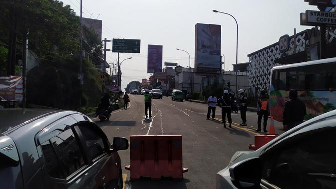 Petugas gabungan menutup jalan menuju kawasan Puncak Bogor, Sabtu (12/9/2020). Polisi menerapkan rekayasa lalu lintas satu arah untuk mengurai kepadatan di kawasan Puncak. (Liputan6.com/Achmad Sudarno)