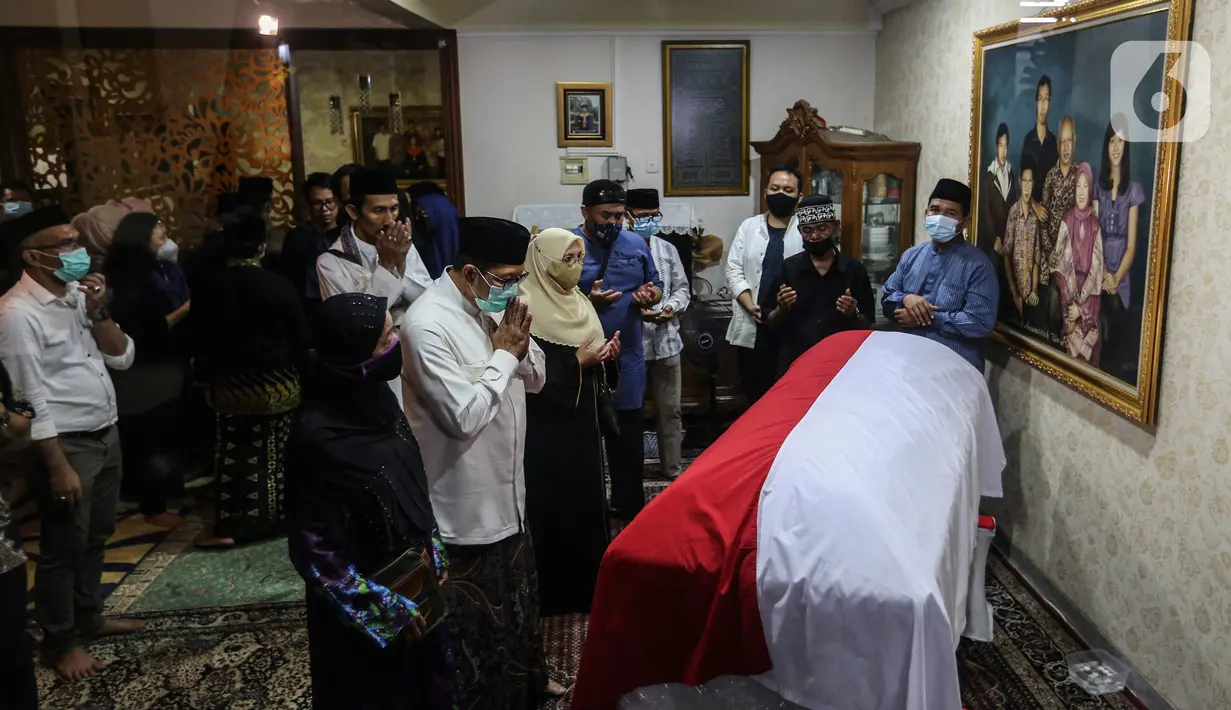 Saudara serta Kerabat berdoa di depan Peti Jenazah Ketua Dewan Pers Azyumardi Azra di rumah duka di Perumahan Puri Laras II, Cirendeu, Tangerang Selatan, Selasa (20/9/2022) dinihari. Azyumardi Azra meninggal dunia pada Minggu (18/9/2022) di rumah sakit Kedah, Selangor, Malaysia pukul 12.30 waktu setempat, dan rencana akan dimakamkan Selasa (20/9/2022) di Taman Makam Pahlawan (TMP) Kalibata. (Liputan6.com/Johan Tallo)