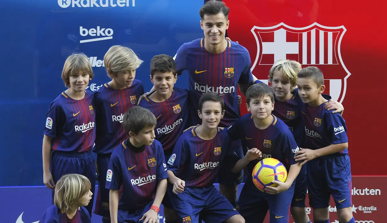 Philippe Coutinho melakukan sesi foto bersama anak-anak usai perkenalan di Camp Nou stadium, Barcelona, Spain, (8/01/2018). Coutinho bergabung dengan Barcelona dari Liverpool dengan nilai transfer sebesar 160 juta euro. (AFP/Lluis Gene)