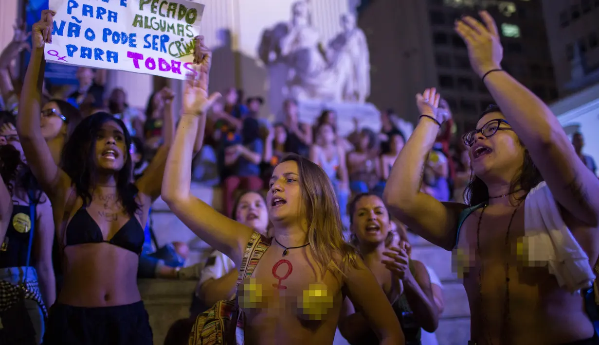 Dua orang wanita bertelanjang dada saat menggelar protes pelarangan aborsi di Rio de Janeiro, Brasil (13/11). Ribuan orang turun ke jalan untuk menggelar protes adanya larangan aborsi di Brasil. (AFP Photo/Mauro Pimentel)