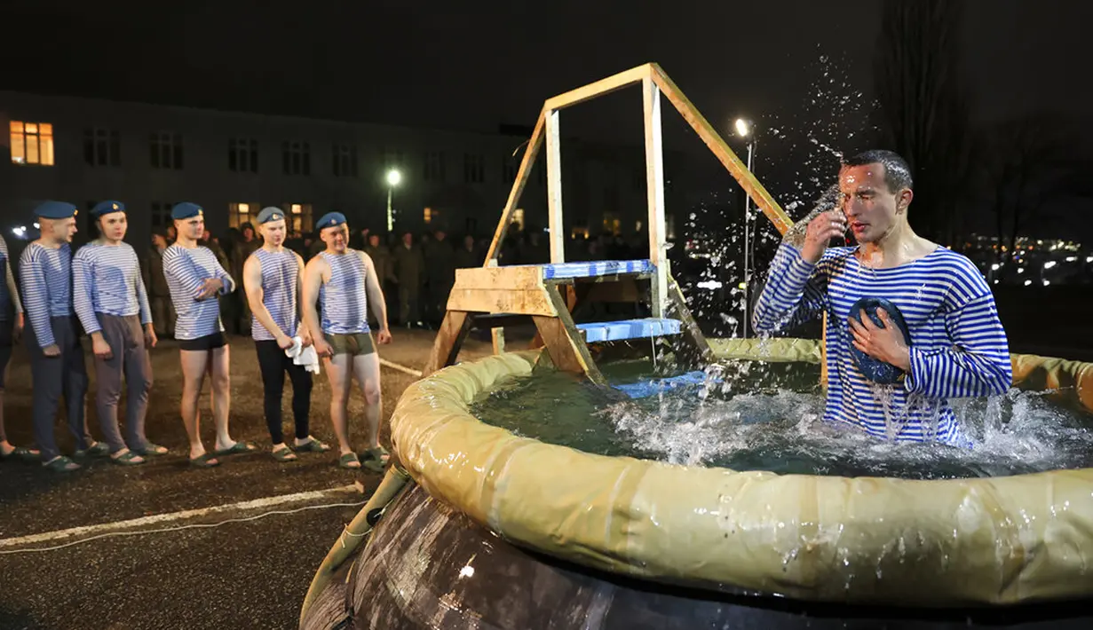 Seorang penerjun payung Rusia mengantre untuk untuk mandi dalam air dingin saat Epiphany tradisional dekat Novorossiysk, Krasnodar, Rusia, 18 Januari 2022. (AP Photo/Alexander Zemlianichenko)