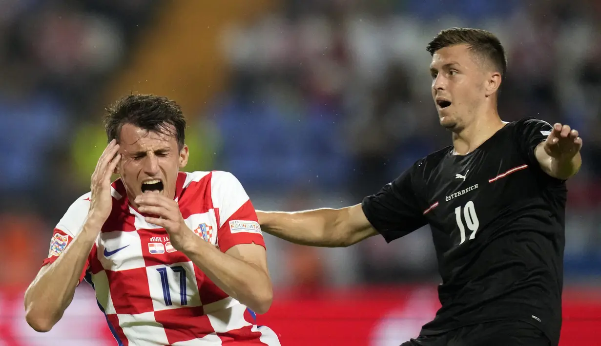 Penyerang timnas Kroasia Ante Budimir berebut bola dengan gelandang Austria Christoph Baumgartner  pada matchday pertama UEFA Nations League A Grup 1 di Stadion Gradski Vrt, Sabtu (4/6/2022) dinihari WIB. Ralf Rangnick sukses debut dengan mengantarkan Timnas Austria menang telak atas Kroasia dengan skor 3-0. (AP Photo/Darko Bandic)
