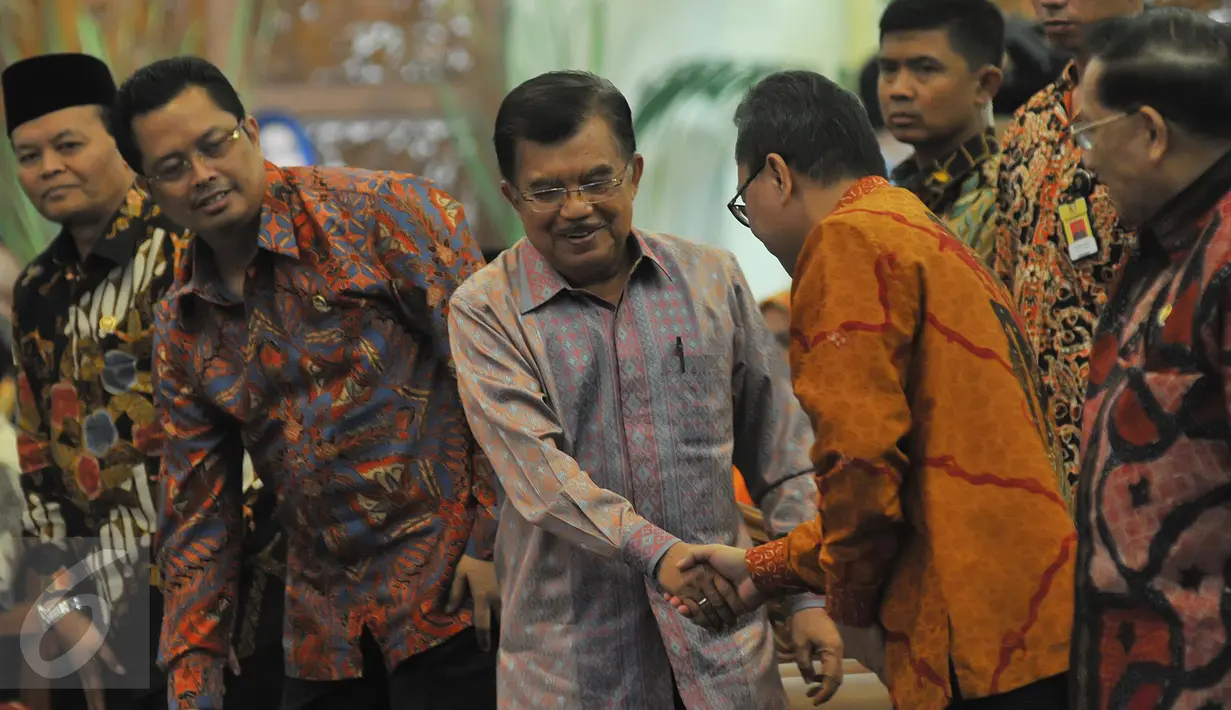 Wapres Jusuf Kalla (tengah) berjabat tangan dengan Ketua MPR Zulkifli Hasan saat menghadiri peringatan Hari Konstitusi di Kompleks Parlemen, Senayan, Jakarta, Selasa (18/8/2015). (Liputan6.com/Herman Zakharia)