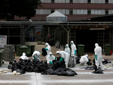 Petugas kesehatan menyisihkan unggas ke tempat sampah di sebuah pasar di Hong Kong, (7/6).  Pihak berwenang memutuskan untuk menangguhkan perdagangan unggas hidup setelah pemeriksaan menunjukkan adanya virus flu burung H7N9. (REUTERS/Bobby Yip)