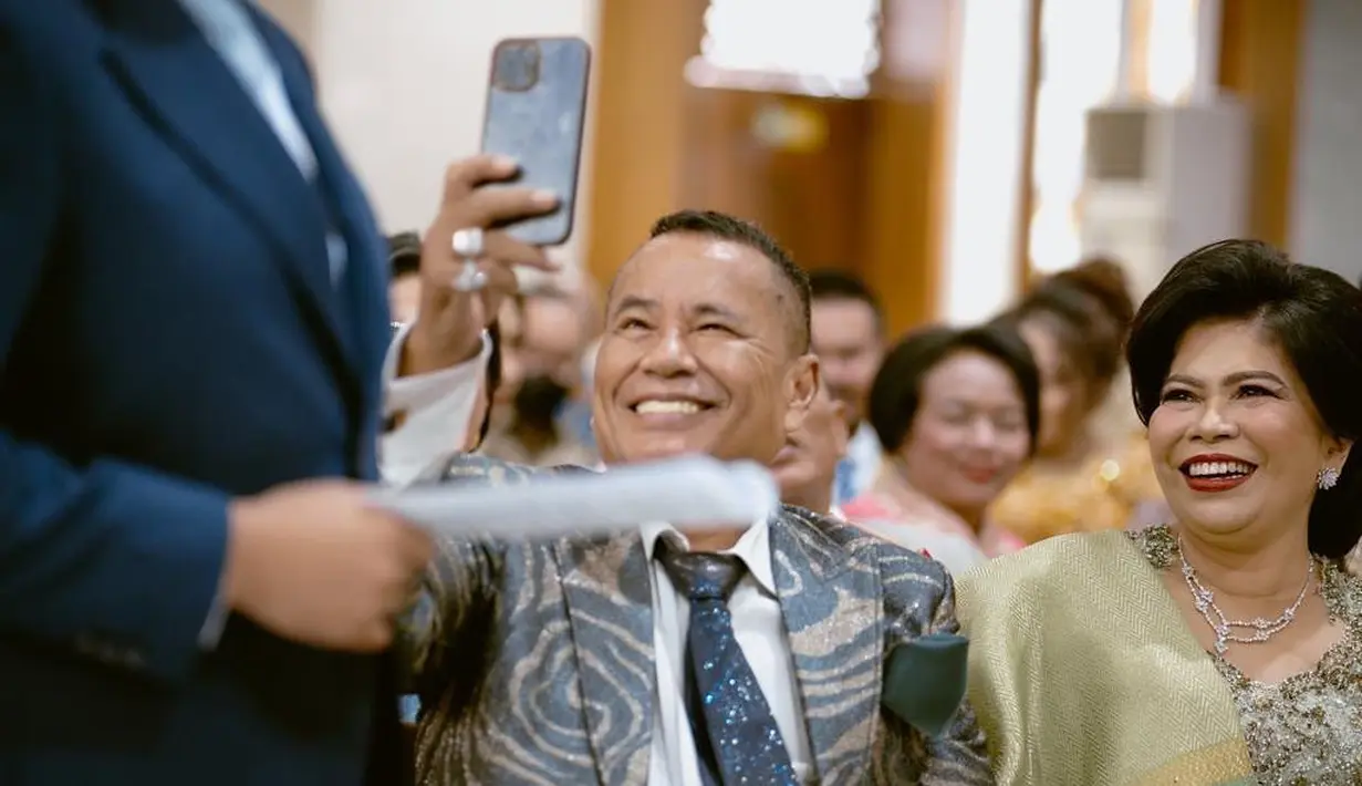 Hotman Paris sendiri mengunggah foto menarik di akun Instagramnya. Ia memilih tampil dengan setelan jas bermotif abstrak, kemeja putih, dan dasi bermotif galaksi. Hotman Paris tampil bersebelahan dengan sang istri yang tak kalah memesona dalam balutan kebaya serasi dengan Felicia Hutapea. [Foto: Instagram]